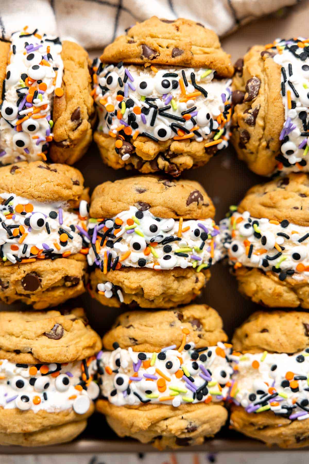 a tray of halloween ice cream sandwiched with cookies, ice cream, and halloween sprinkles.