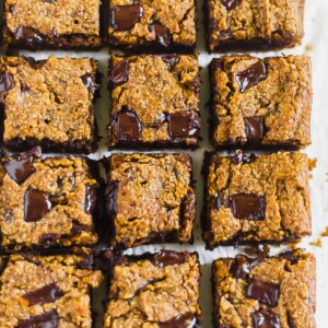 12 squares of paleo pumpkin blondies with chocolate chunks on top