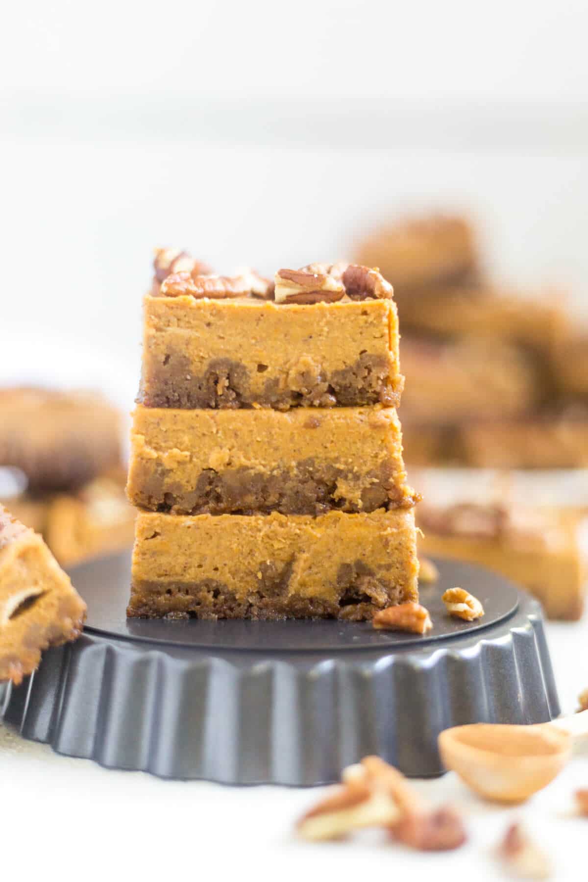 Pumpkin pie bars are a fun twist on a classic Thanksgiving recipe! The crust is made from crushed gingerbread and the bars are just like pumpkin pie and topped with pecans, caramel, ice cream and more!