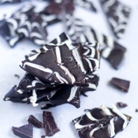 Sugar free spiderweb bark is a sweet and healthy Halloween treat for kids. The base is made of dark chocolate, coconut oil and pure maple syrup and the decorations are made with coconut butter. This festive design is easy to make and you don't even have to bake it!