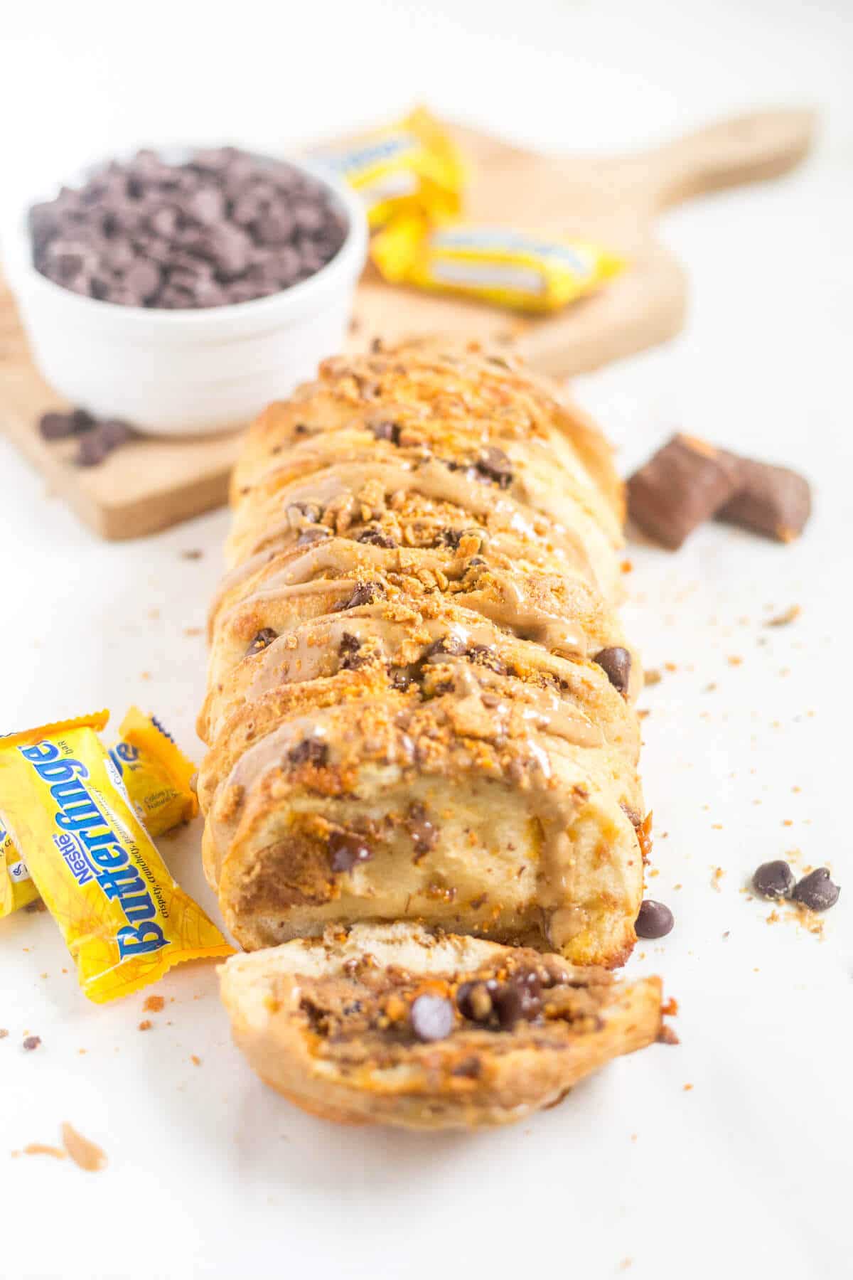 Chocolate peanut butter pull apart bread is an easy dessert recipe to share! It’s made with canned biscuits, chocolate, peanut butter and crushed Butterfinger. The ingredients come together in minutes and bake to flaky perfection. Just in time for Thanksgiving and fall parties!