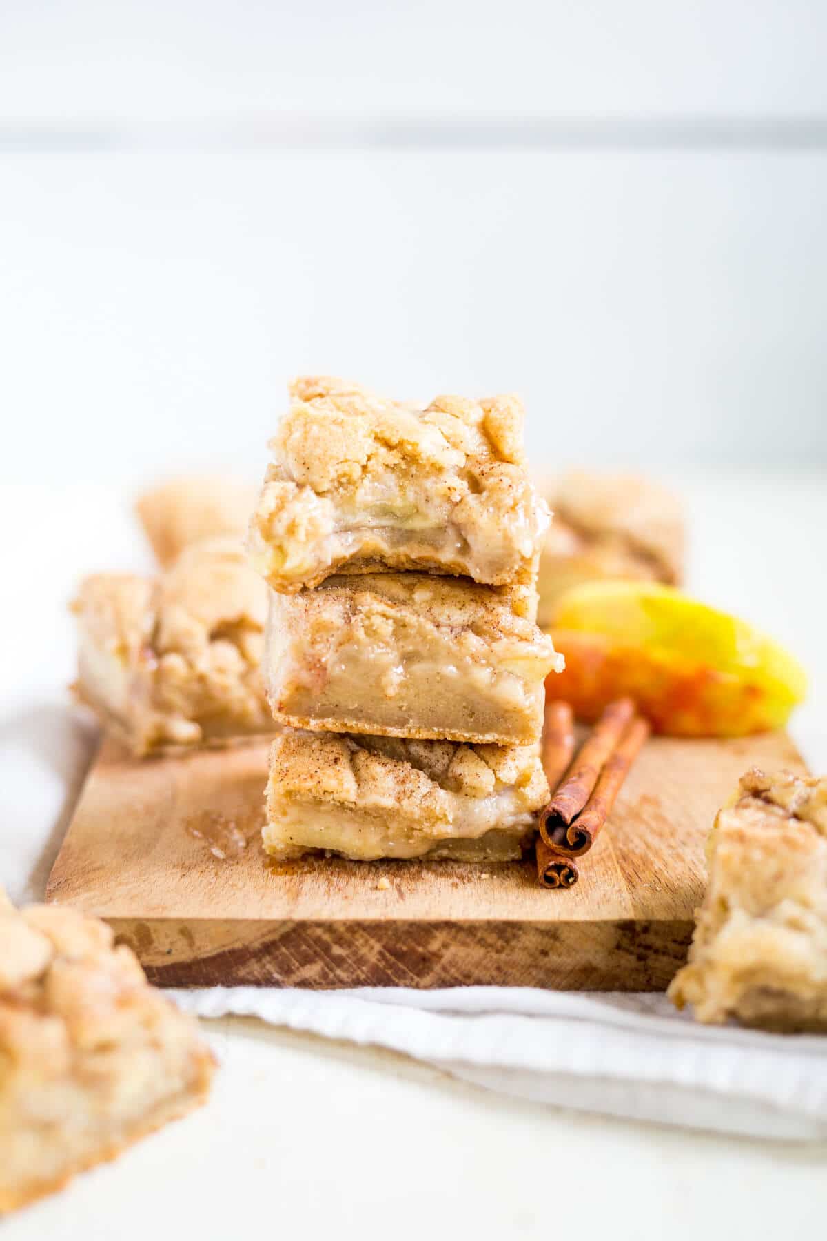 three apple pie bars stacked on a cutting board