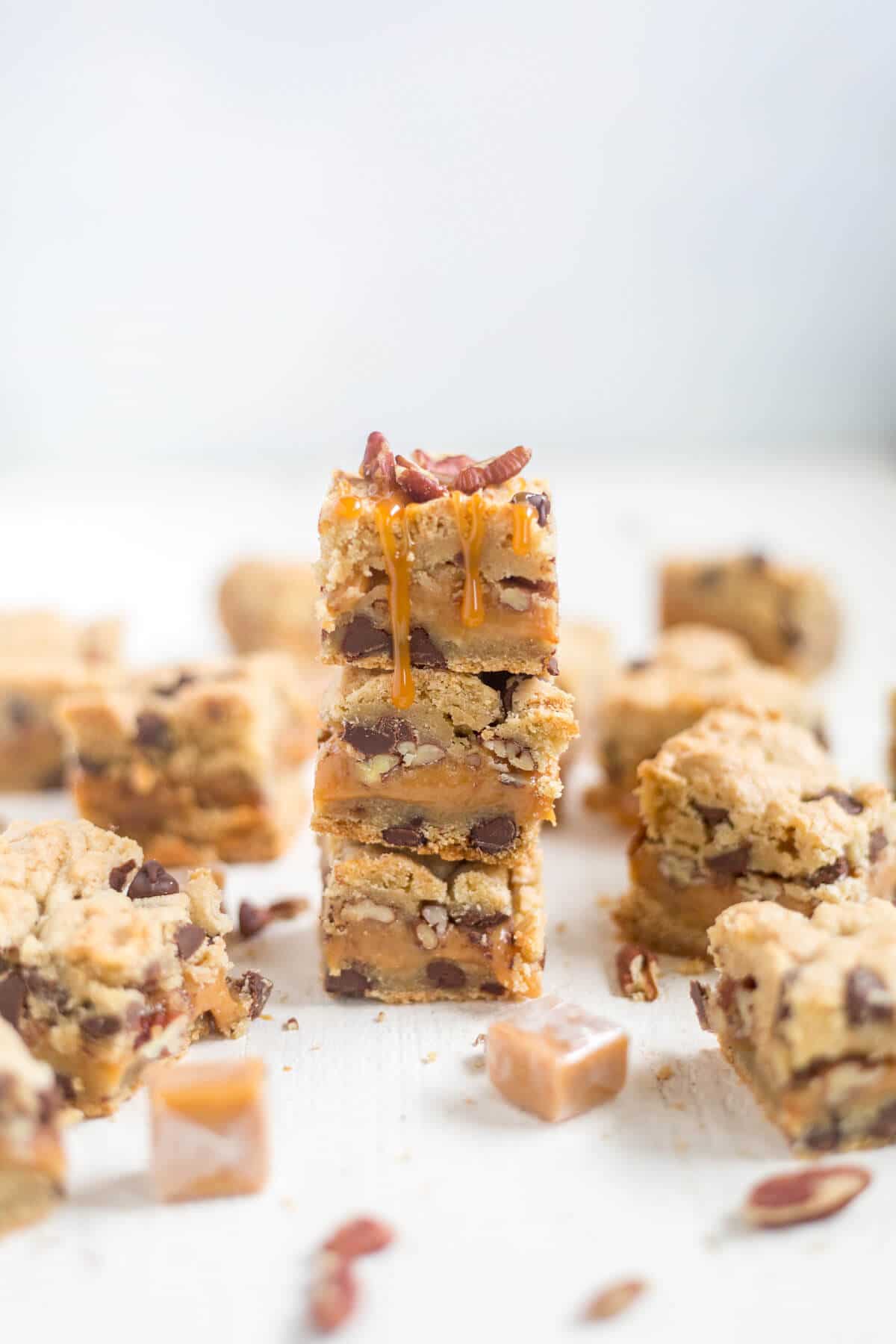 Thick and chewy turtle cookie bars! The base of this recipe is a chocolate chip cookie. You'll split the dough in half and add some caramel and pecans to the middle for an easy, chewy dessert!