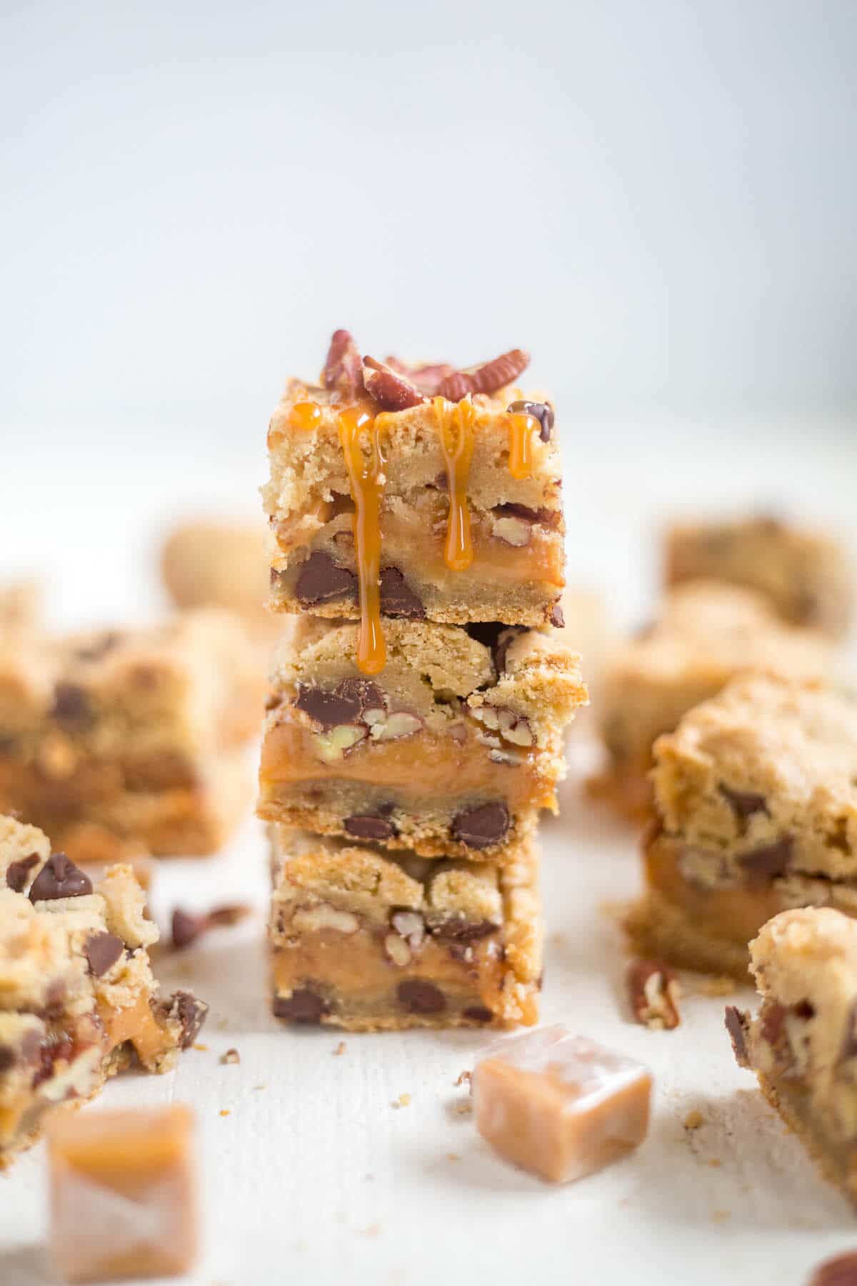 Thick and chewy turtle cookie bars! The base of this recipe is a chocolate chip cookie. You'll split the dough in half and add some caramel and pecans to the middle for an easy, chewy dessert!