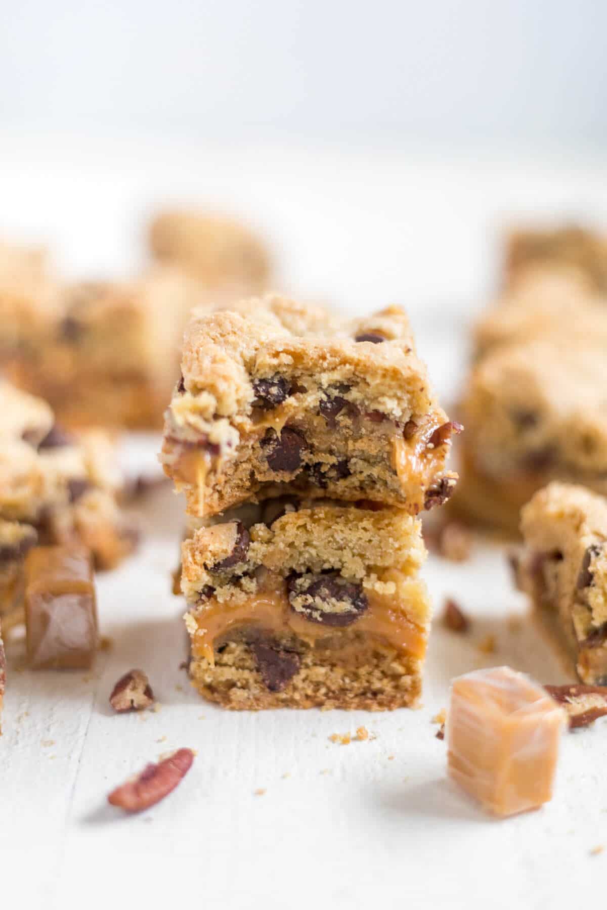 Thick and chewy turtle cookie bars! The base of this recipe is a chocolate chip cookie. You'll split the dough in half and add some caramel and pecans to the middle for an easy, chewy dessert!