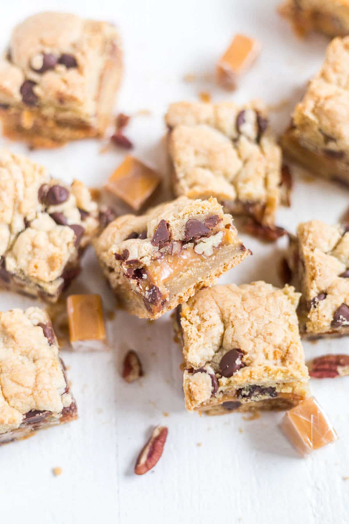 Thick and chewy turtle cookie bars! The base of this recipe is a chocolate chip cookie. You'll split the dough in half and add some caramel and pecans to the middle for an easy, chewy dessert!