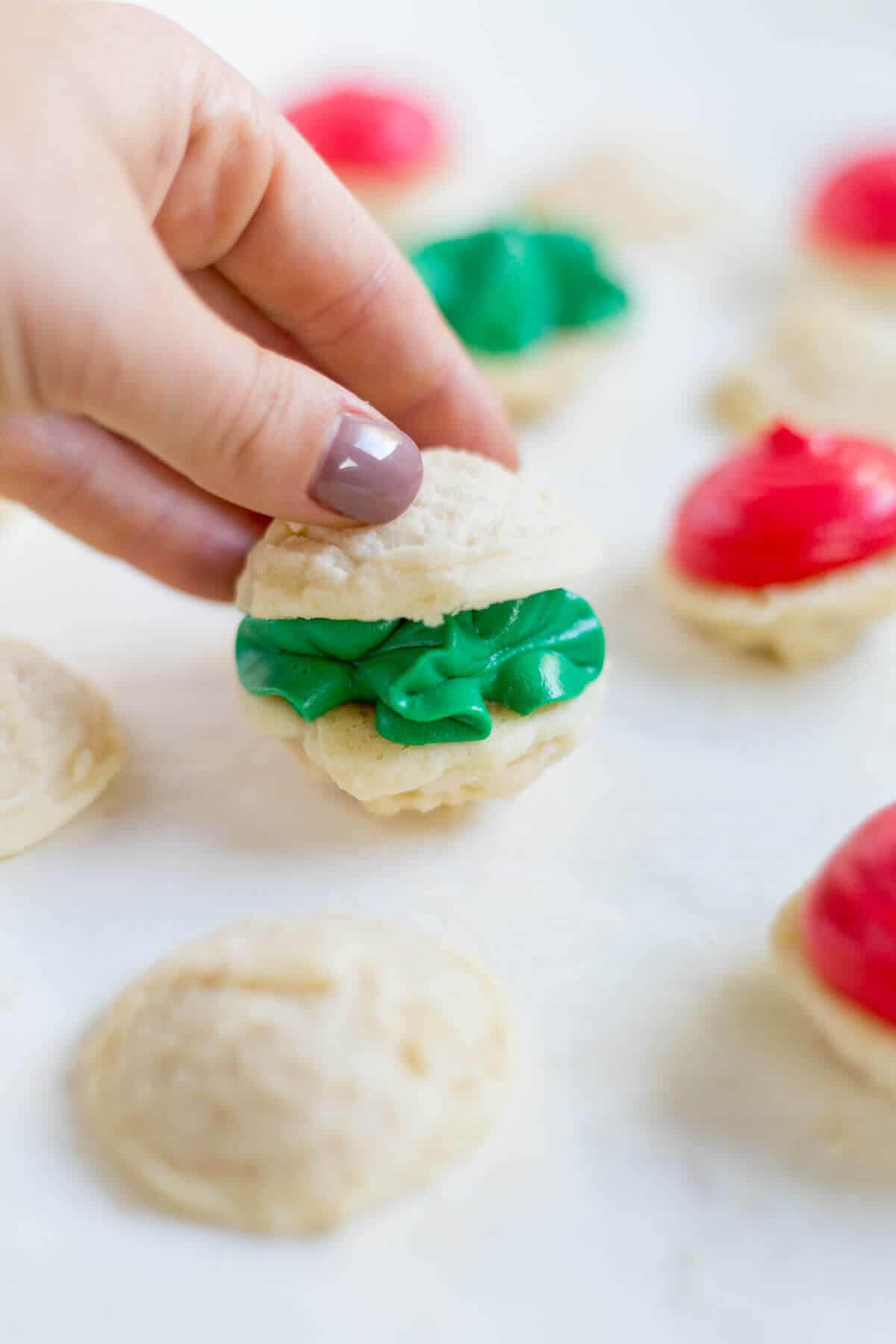 Melting moments sandwich cookies are a must-make Christmas cookie! They're tiny cookies sandwiched with a thick and creamy frosting dyed red and green. This festive cookie recipe will be a new family favorite.