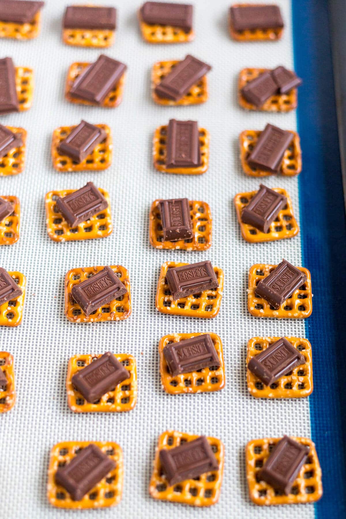 This peppermint pretzel bite recipe will be a huge hit! A pretzel, topped with milk chocolate and sprinkled with peppermint pieces, you can make these bite-sized holiday desserts in under 10 minutes!