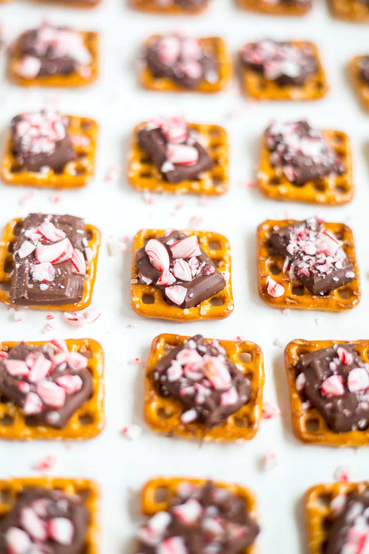 This peppermint pretzel bite recipe will be a huge hit! A pretzel, topped with milk chocolate and sprinkled with peppermint pieces, you can make these bite-sized holiday desserts in under 10 minutes!