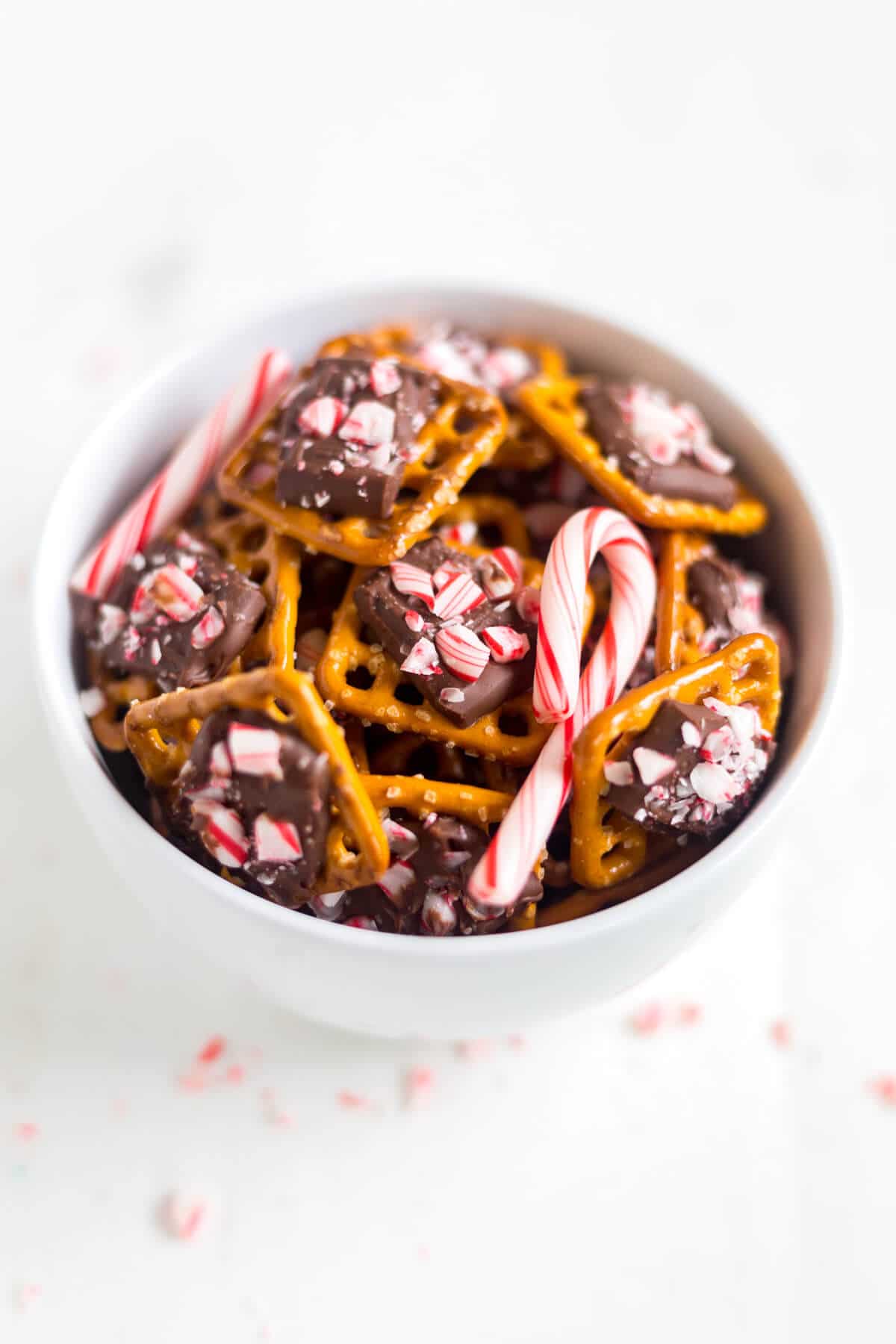 This peppermint pretzel bite recipe will be a huge hit! A pretzel, topped with milk chocolate and sprinkled with peppermint pieces, you can make these bite-sized holiday desserts in under 10 minutes!