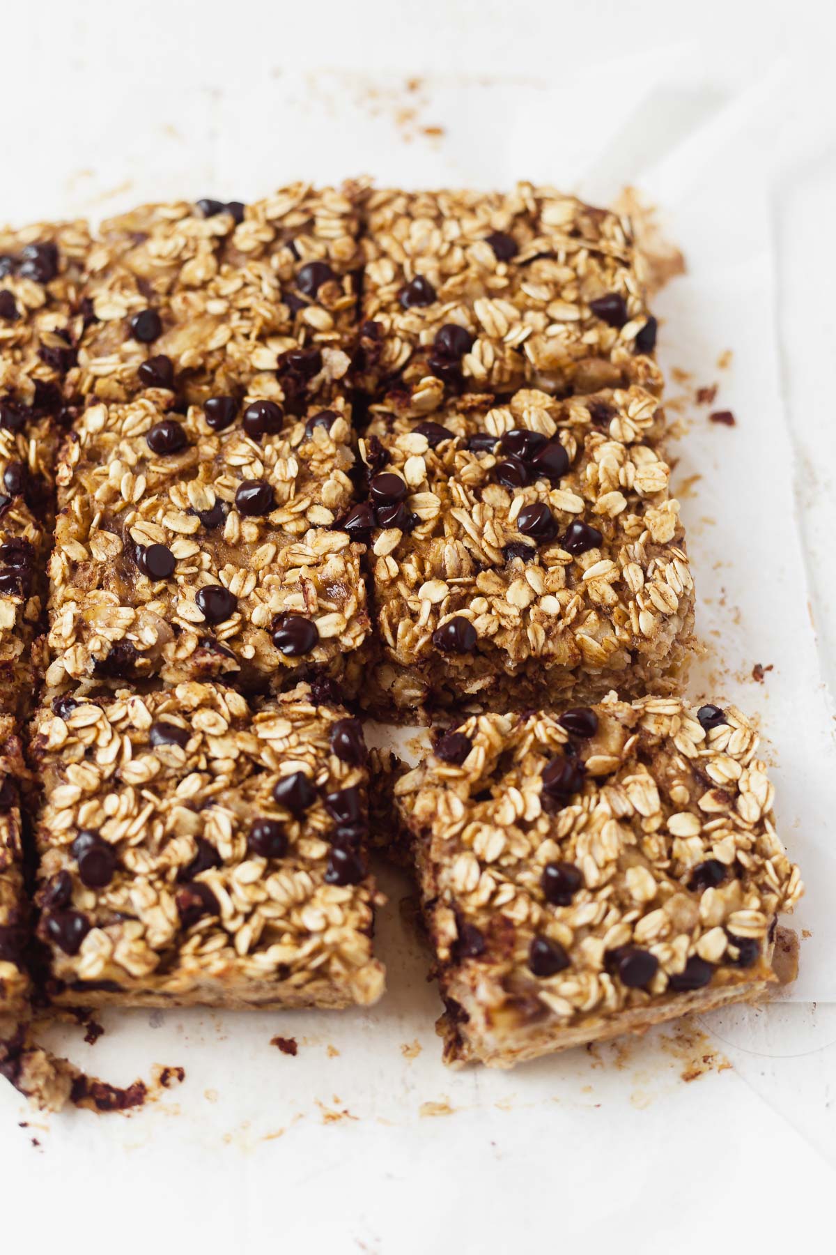 9 squares of banana bread baked oatmeal on a piece of parchment paper