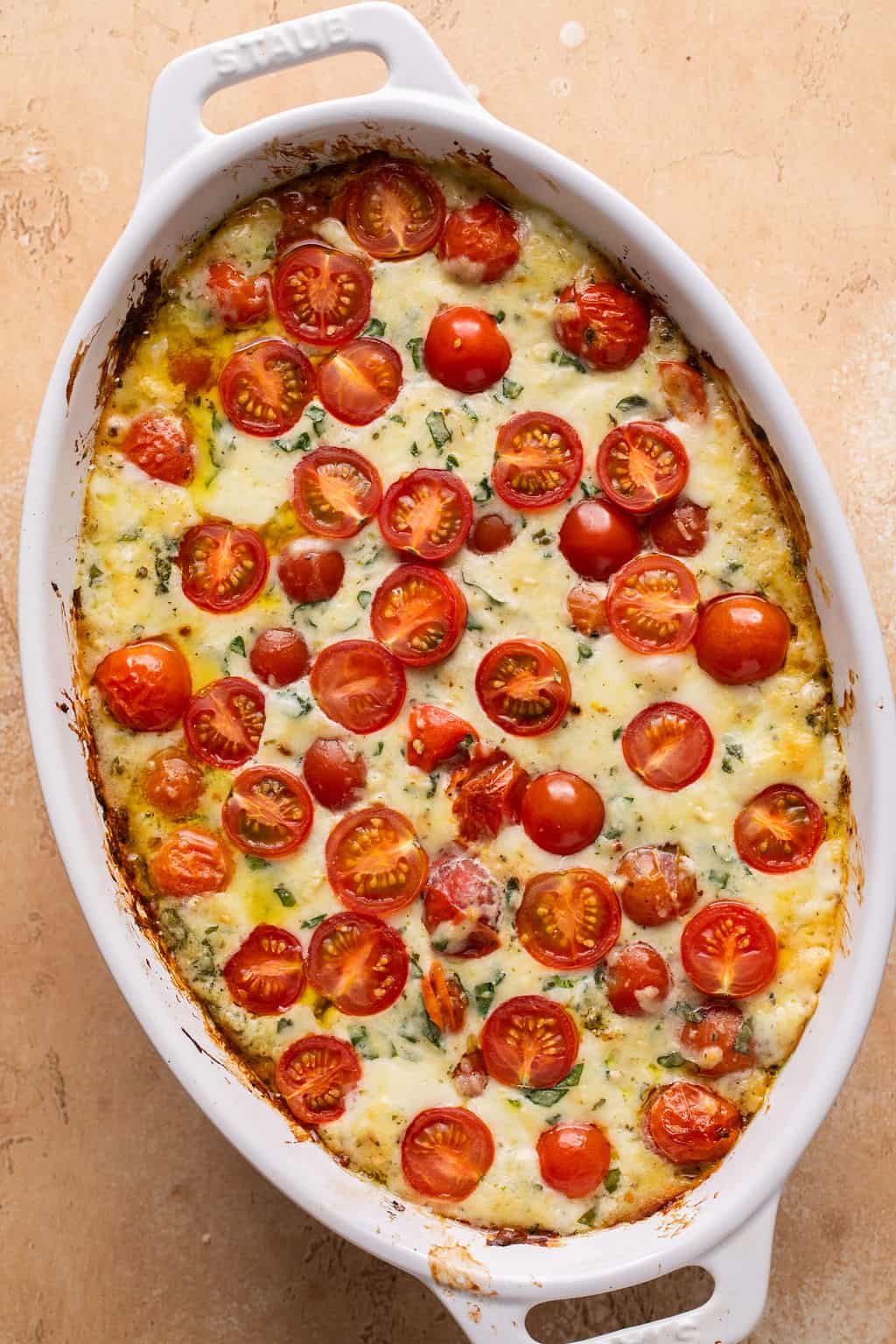 hot caprese dip topped with fresh tomatoes