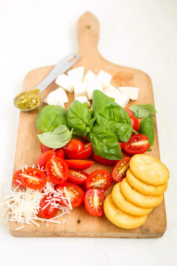 caprese dip ingredients resting on a wooden charceuterie board