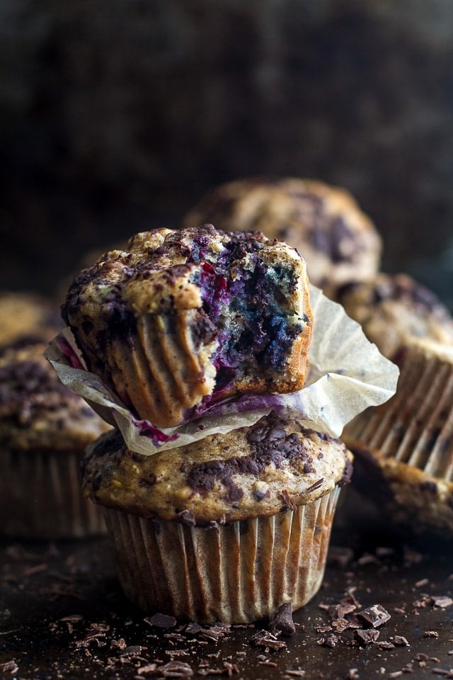 dark chocolate blueberry banana oat muffins with the paper off, stacked on top of each other