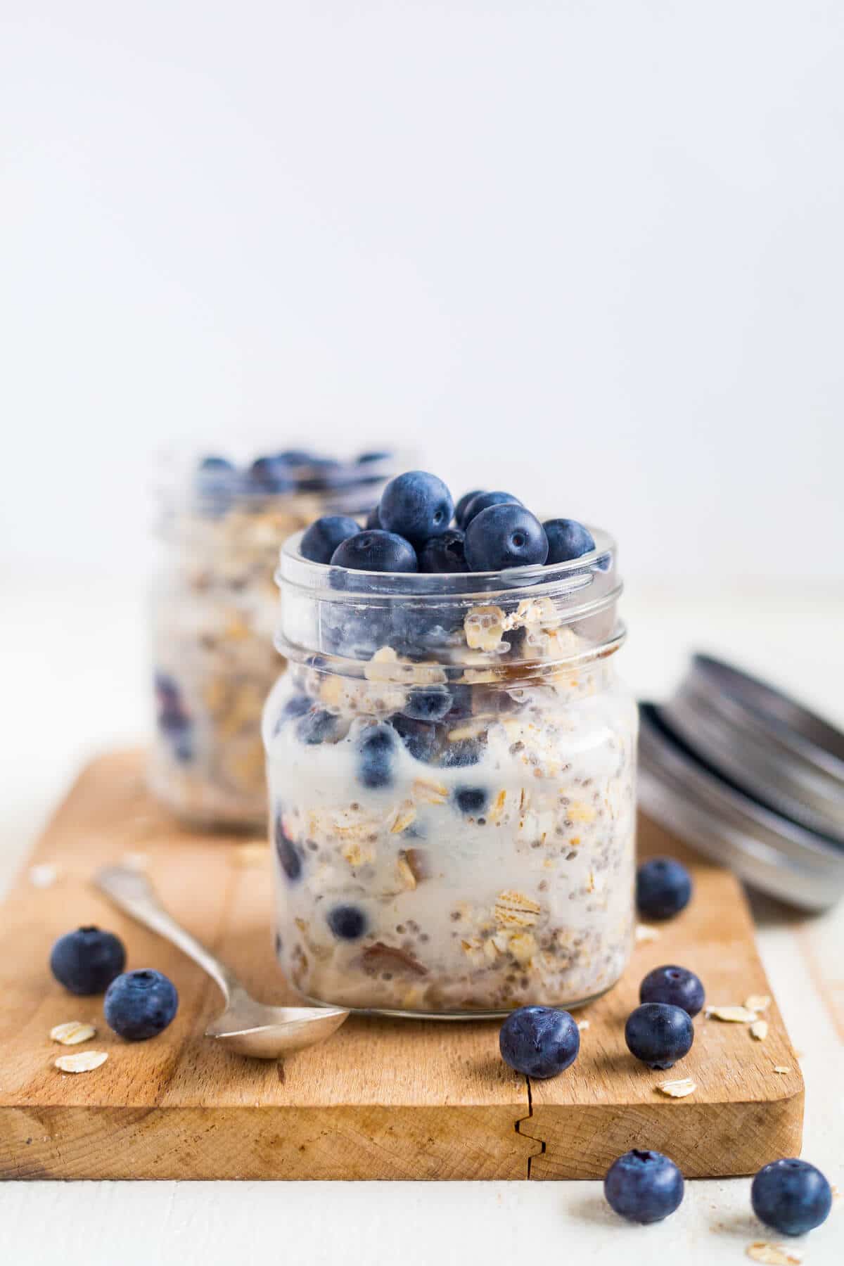 blueberry overnight oats in a small glass mason jar topped with fresh blueberries