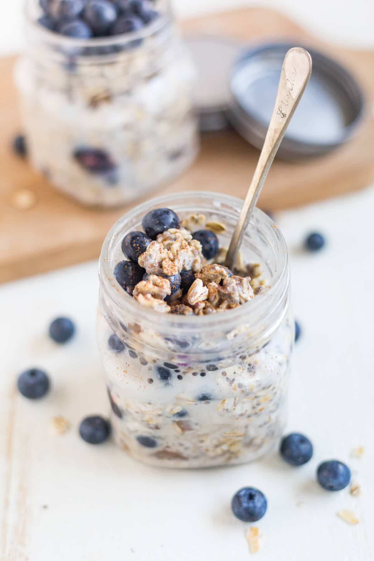 a spoon scooping blueberry overnight oats out of a jar