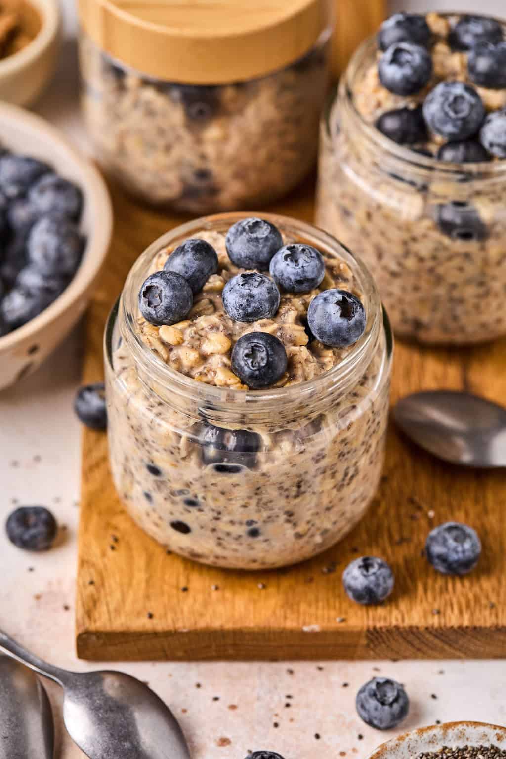 3 jars of blueberry overnight oats with fresh blueberries on top.