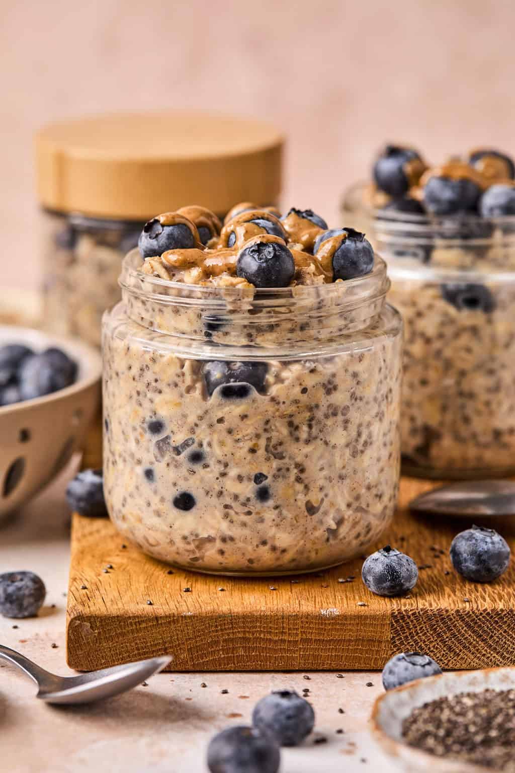 two jars of blueberry overnight oats on a serving board.