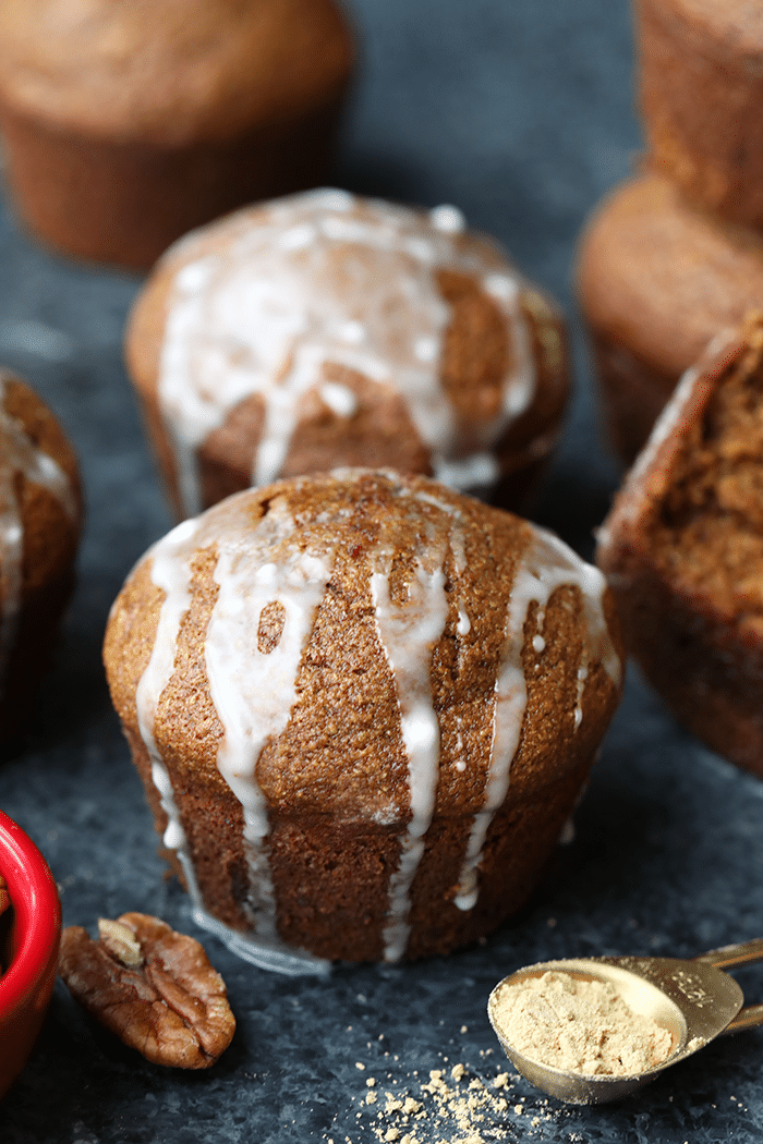 coconut oil gingerbread muffins covered in glaze on a counter