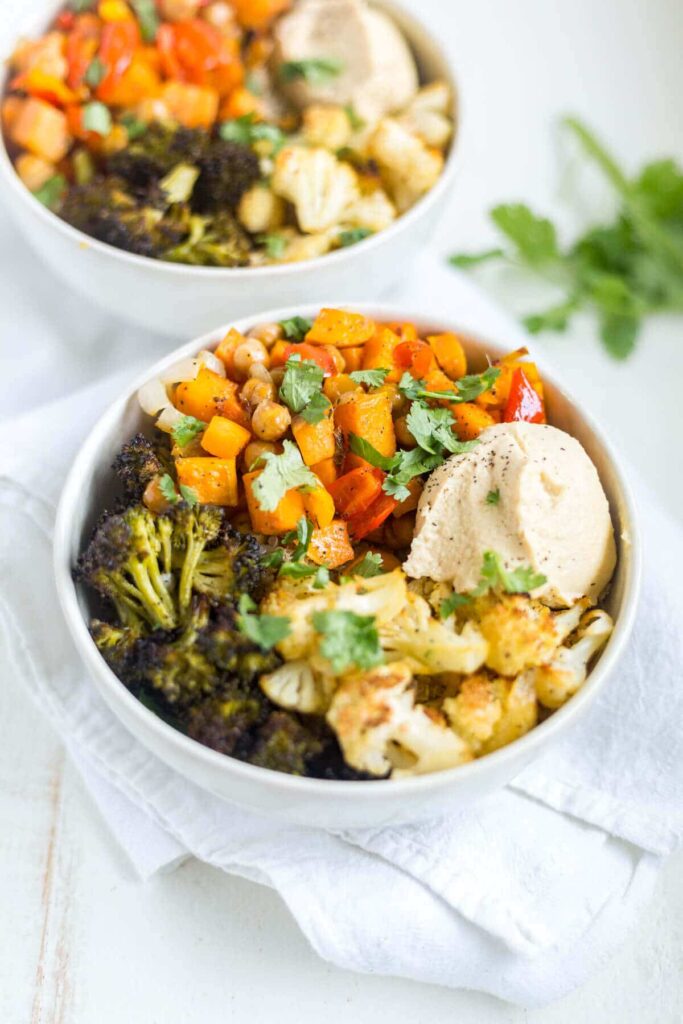 veggie quinoa power bowl with hummus in a white bowl for lunch
