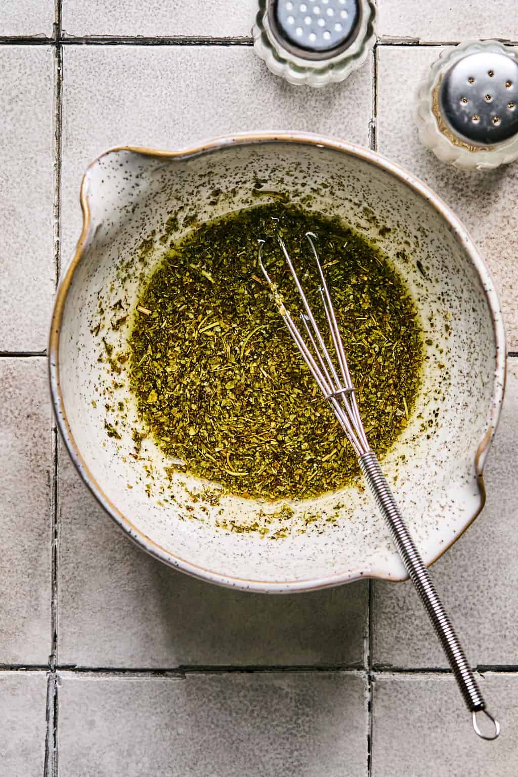 Italian seasoning, olive oil, salt, and pepper mixed in a small bowl