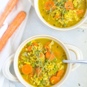 bowls of healthy chicken soup and a spoon in one