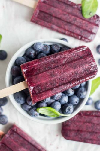 blueberry popsicle on a bowl fresh blueberries