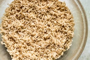 Cooked brown rice in a clear glass bowl, ready to be added to PCOS-friendly chicken soup.