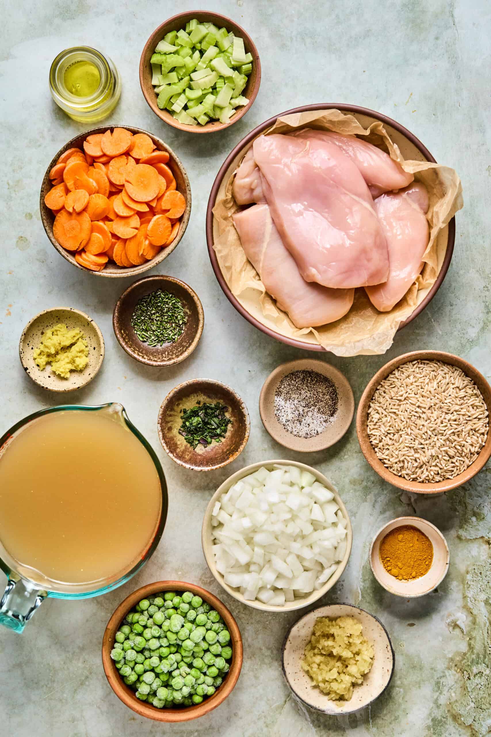 ingredients for chicken soup with brown rice on a counter.