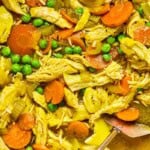 PCOS-friendly chicken soup in a Dutch oven with carrots, peas, shredded chicken, and brown rice.