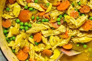 PCOS-friendly chicken soup in a Dutch oven with carrots, peas, shredded chicken, and brown rice.