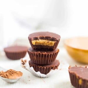 Chocolate Peanut Butter Fat Bombs stacked on top of each other and the top one with a bite taken out of it