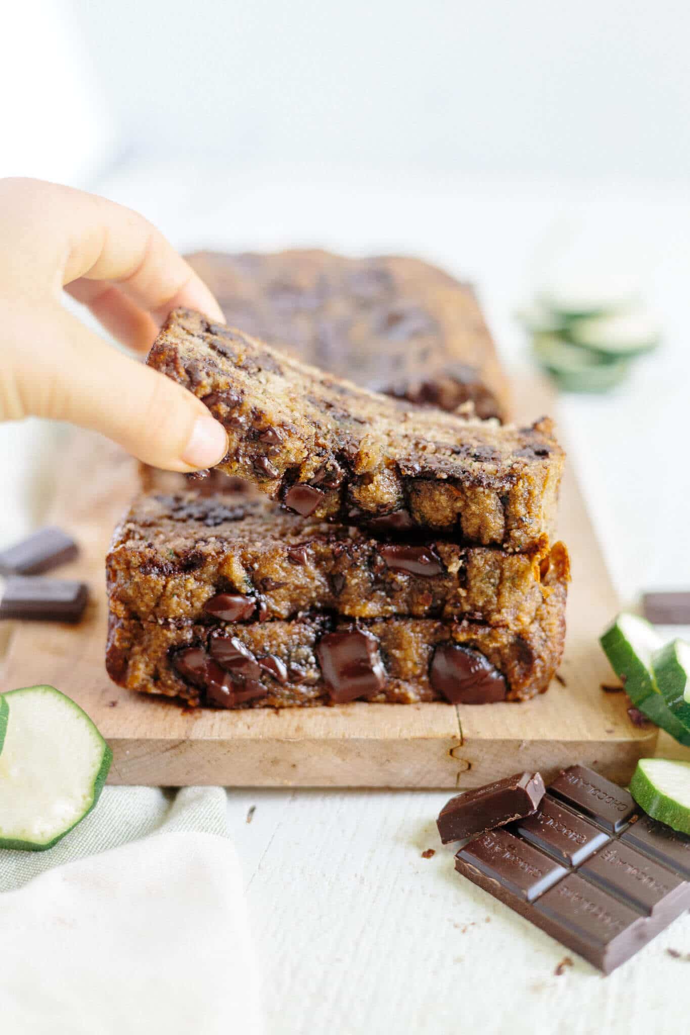 hand grabbing for the top slice of chocolate chip zucchini bread