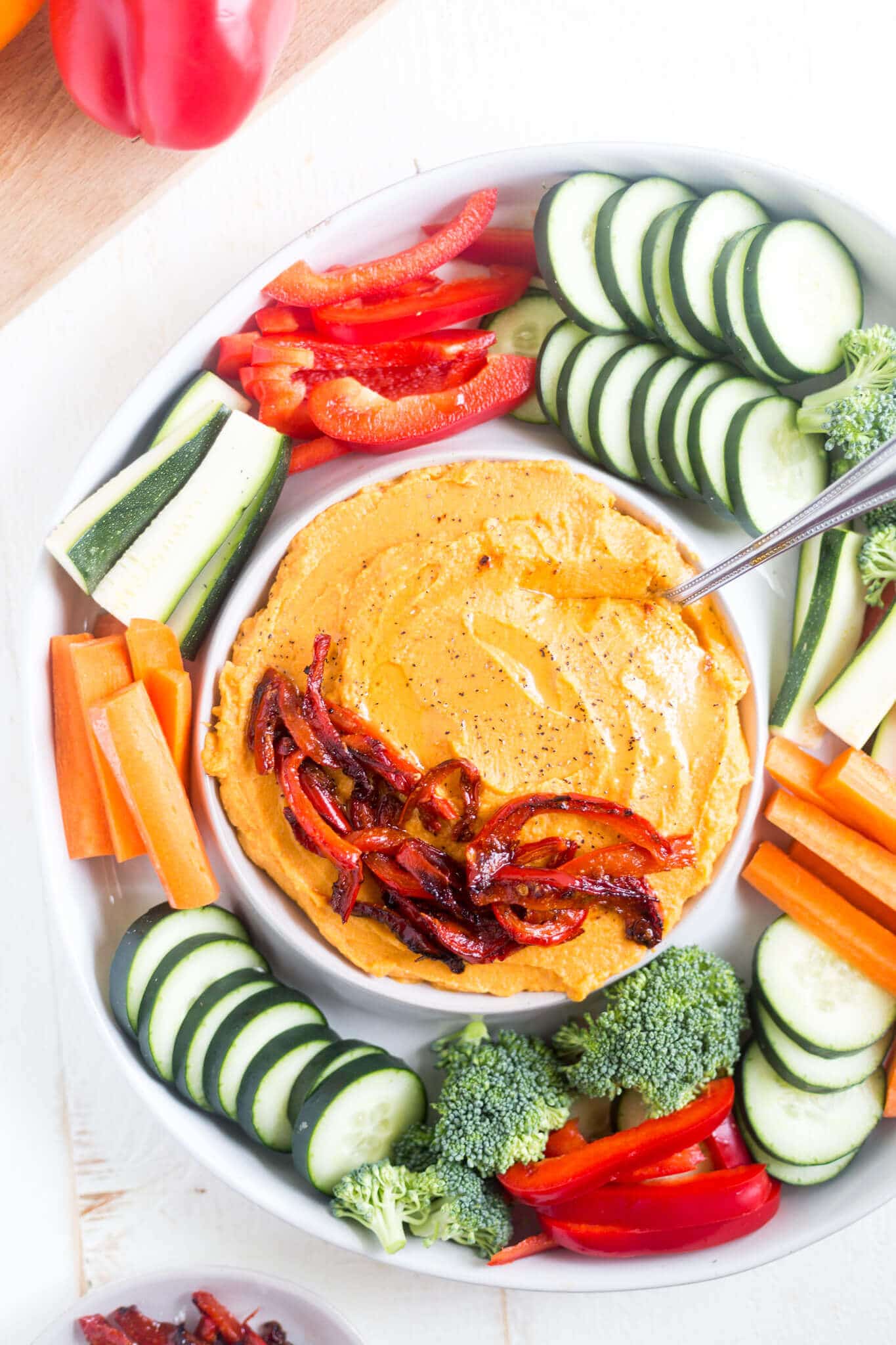 sweet potato hummus recipe in a serving dish with fresh veggies and roasted red peppers