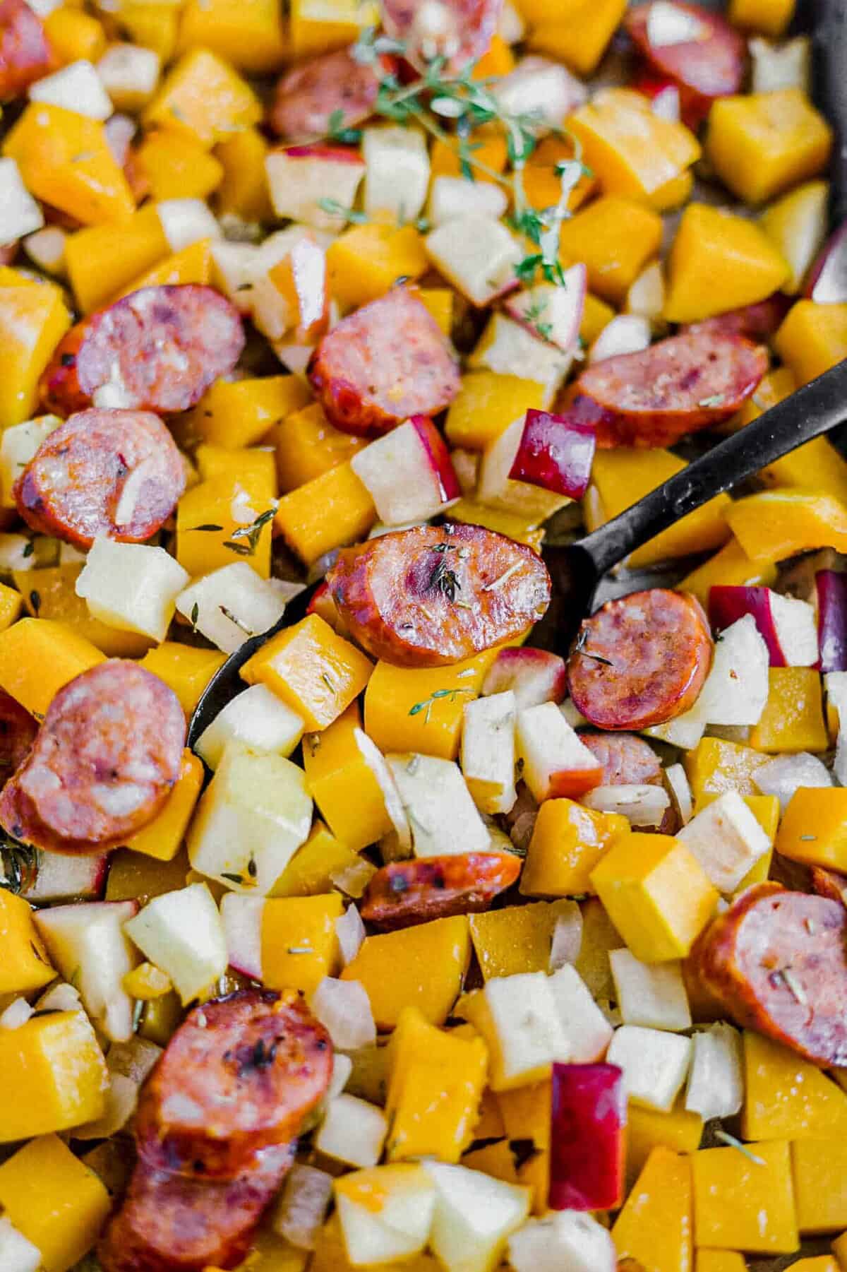 butternut squash, sausage, and apples roasted with thyme on a baking pan