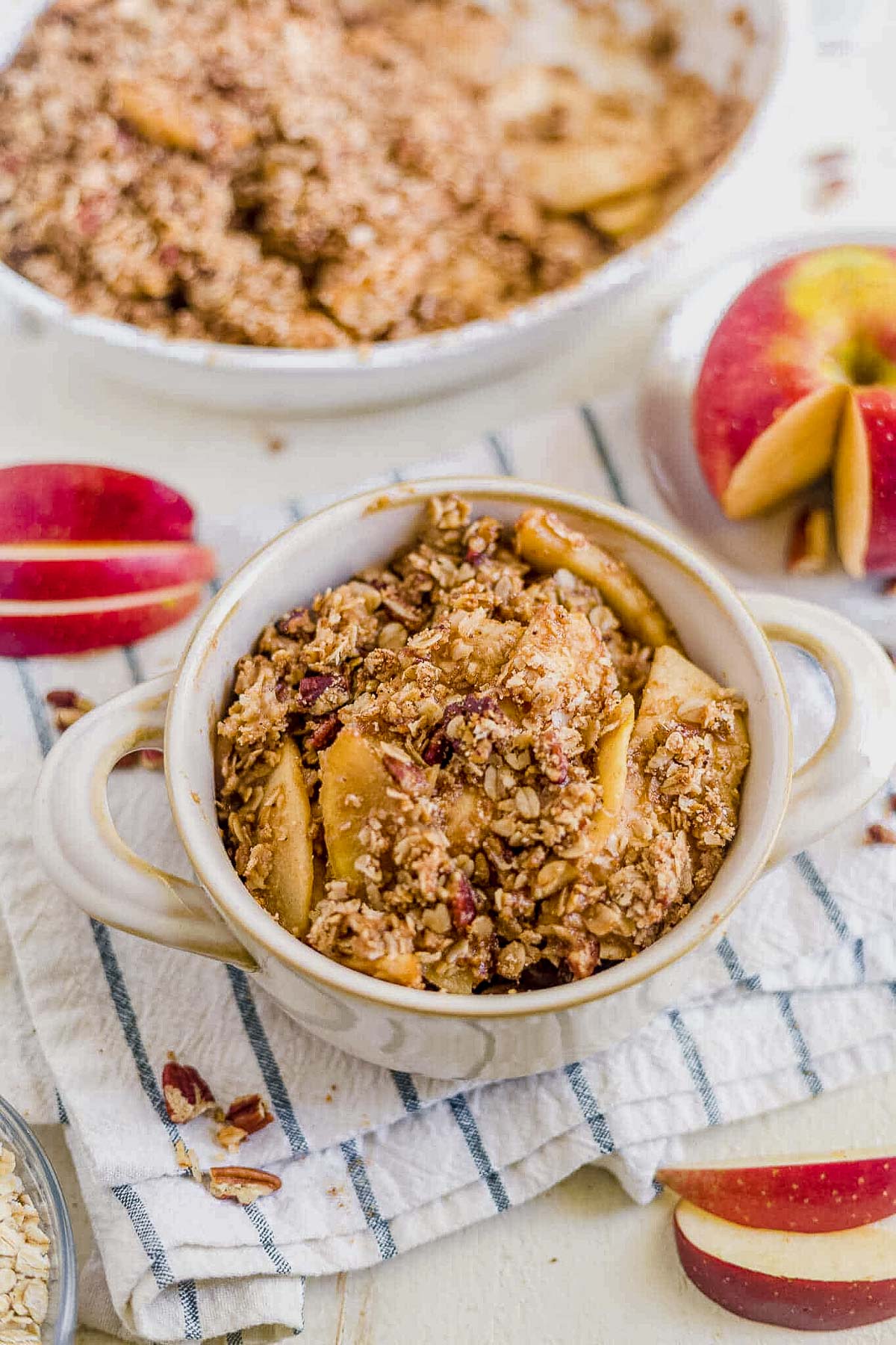 white bowl filled with healthy apple crisp on a white towel