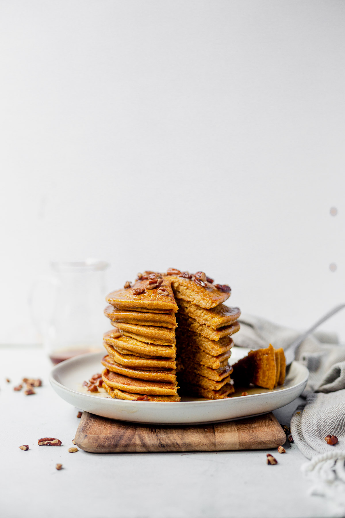 a stack of healthy pumpkin pancakes with a triangle slice cut out of the side