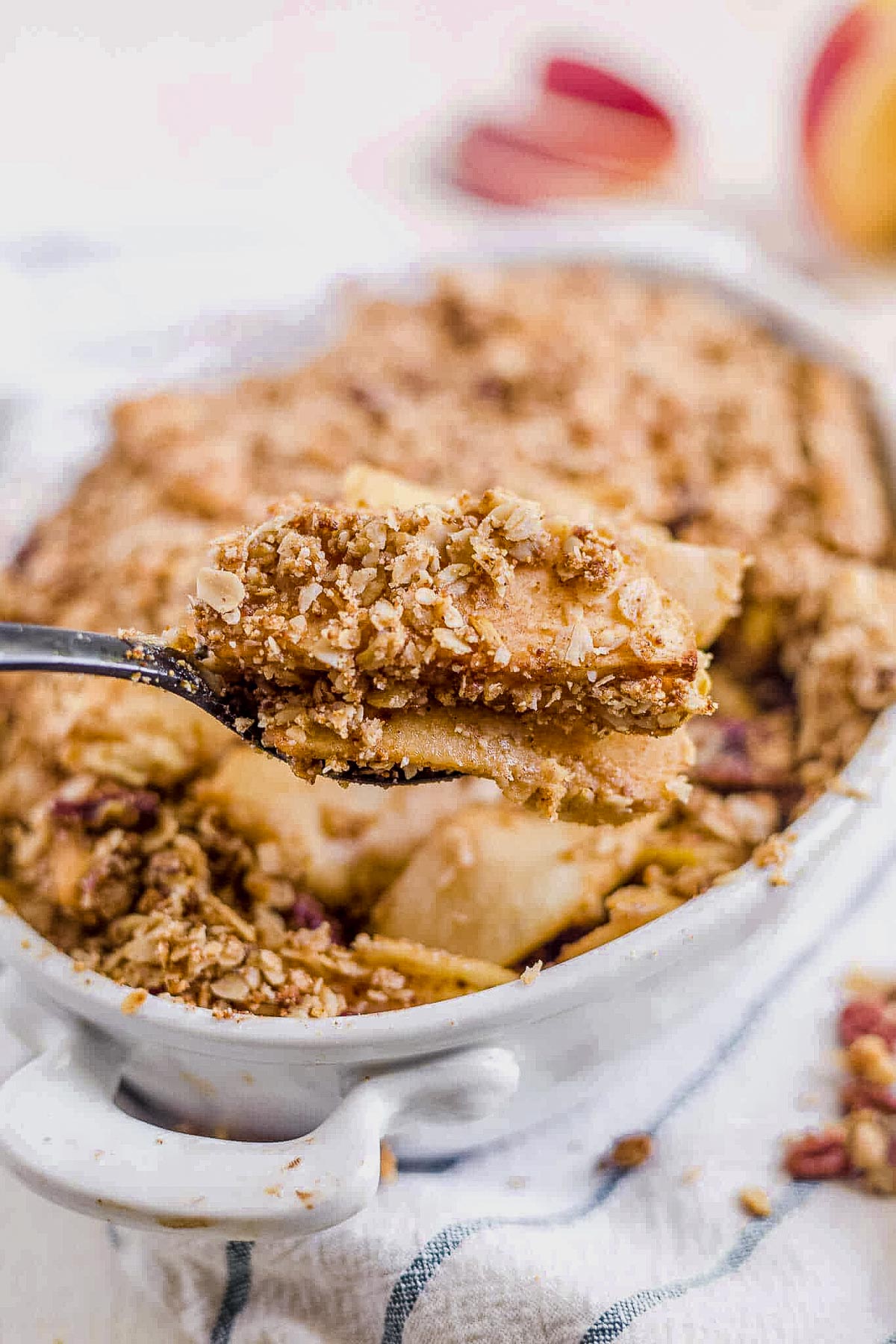 a spoonful of healthy apple crisp coming out of the baking pan