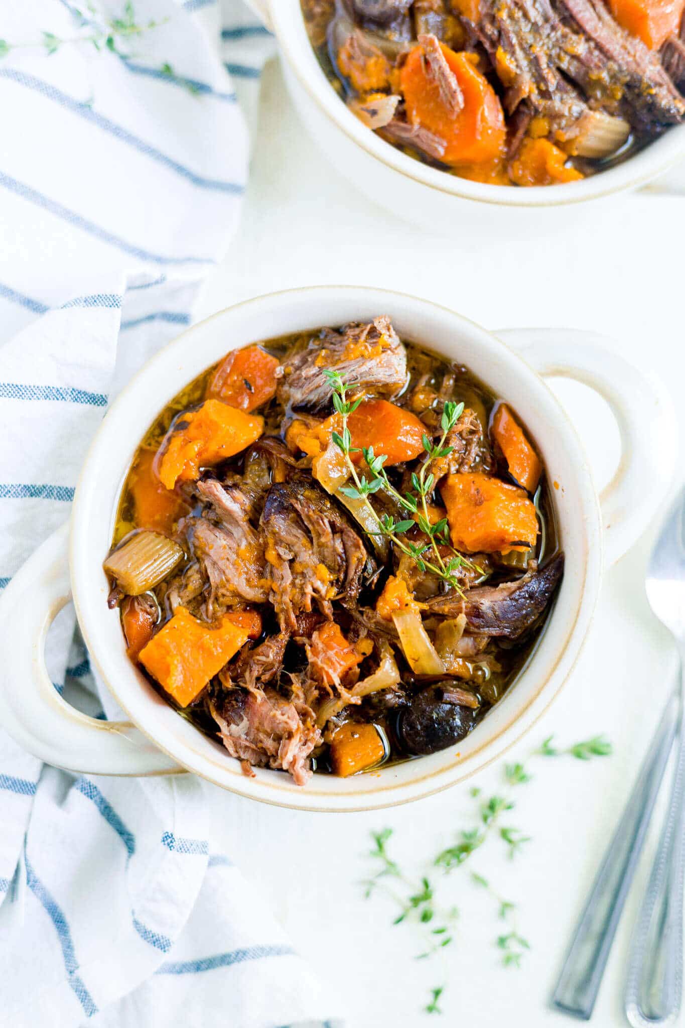 sweet potato beef stew in a bowl with fresh thyme