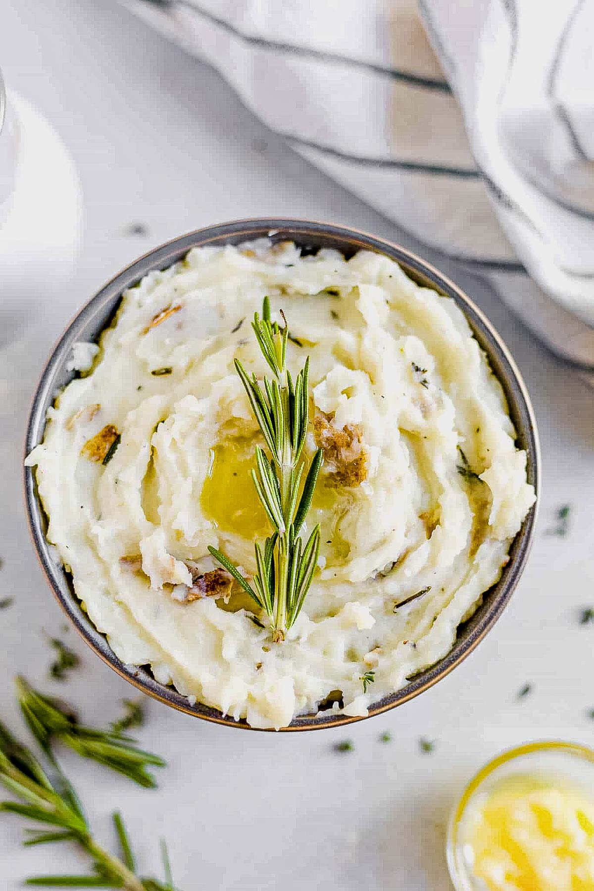 a bowl of vegan mashed potatoes topped with fresh rosemary