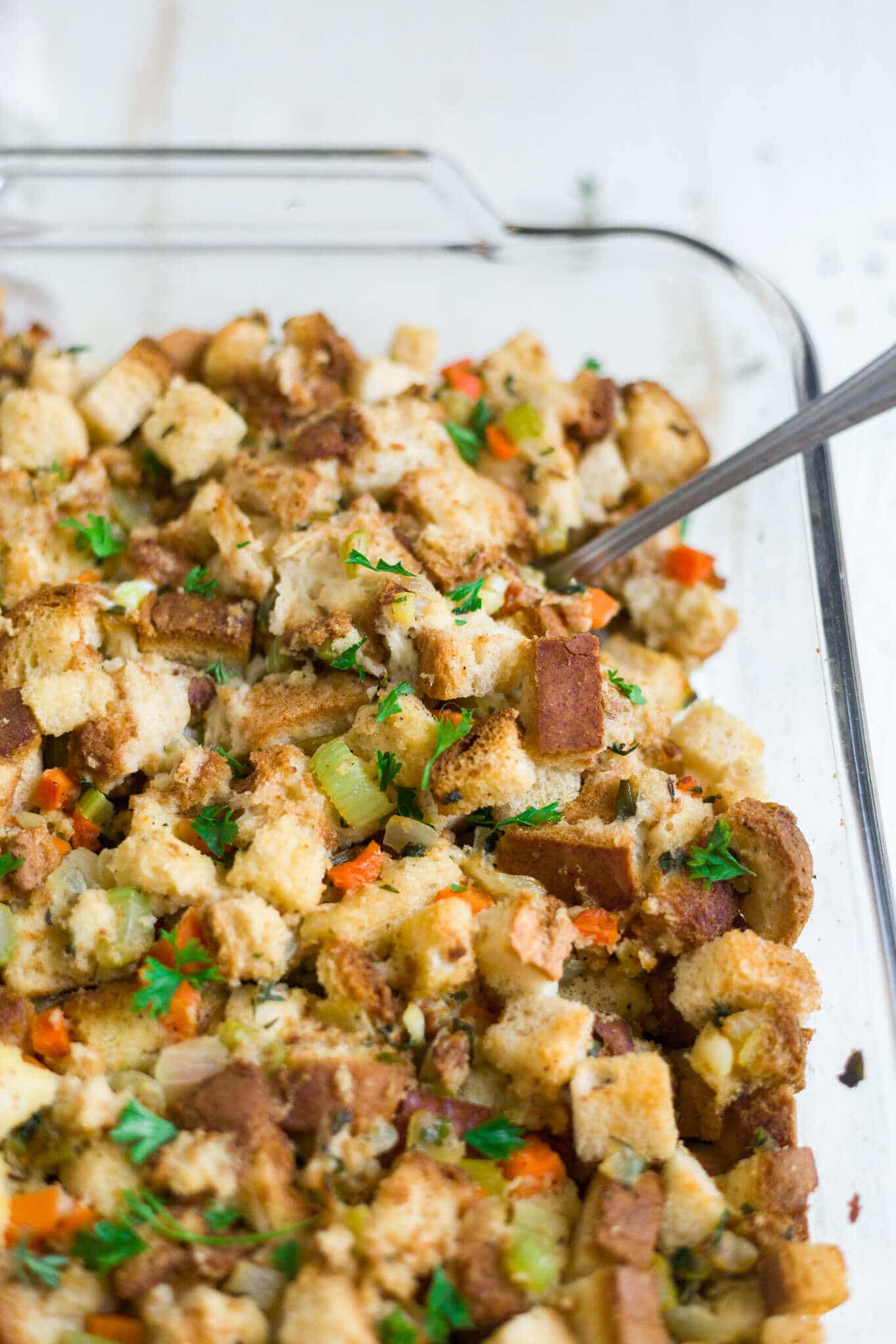 gluten free turkey stuffing recipe in a glass baking dish topped with parsley