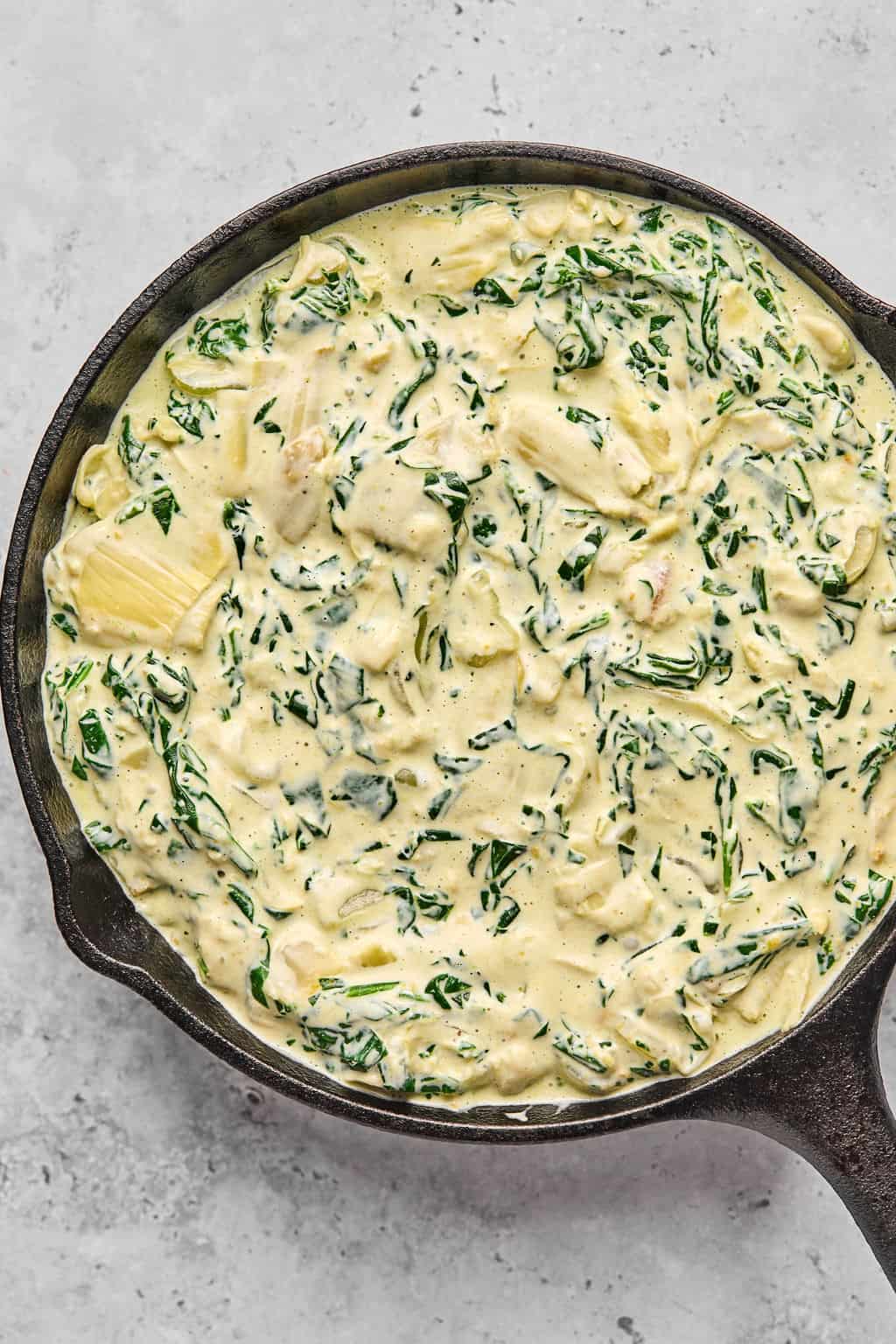 unbaked dip in a cast iron skillet.