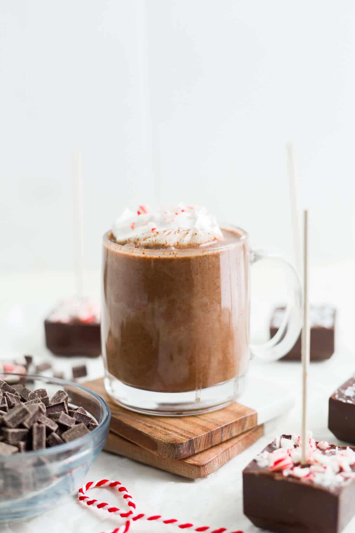a mug of hot chocolate surrounded by hot chocolate sticks