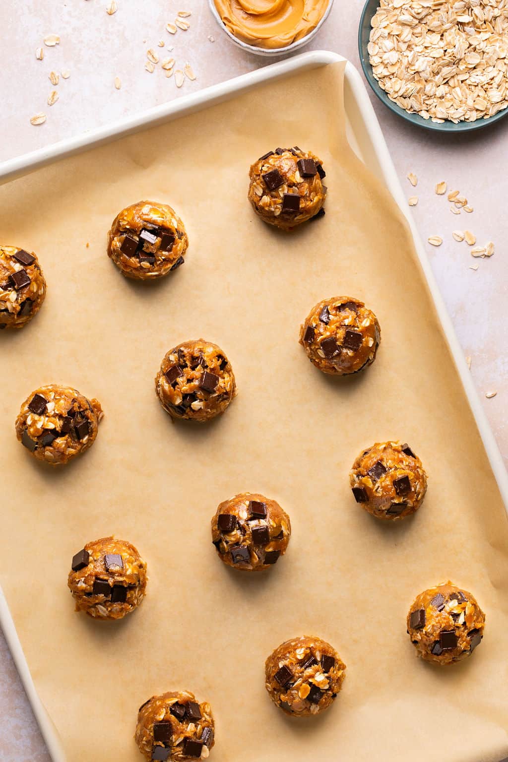 flourless oatmeal cookie dough balls on a parchment lined baking sheet.