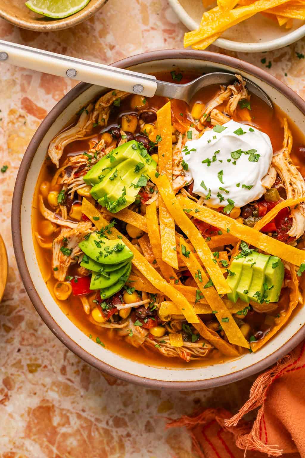 a bowl of healthy chicken tortilla soup in a bowl with homemade tortilla strips