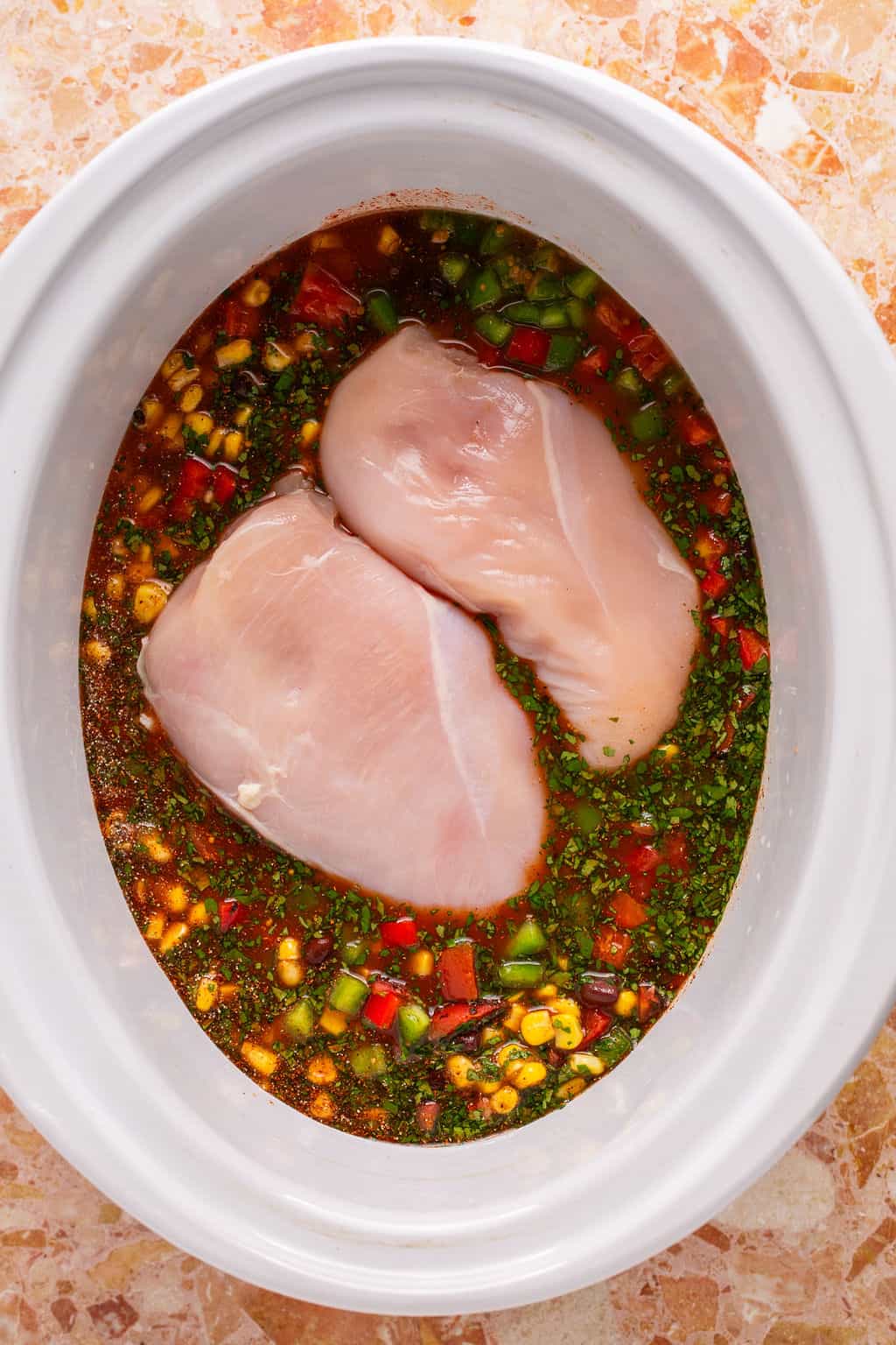 chicken tortilla soup ingredients in a crock pot before cooking.