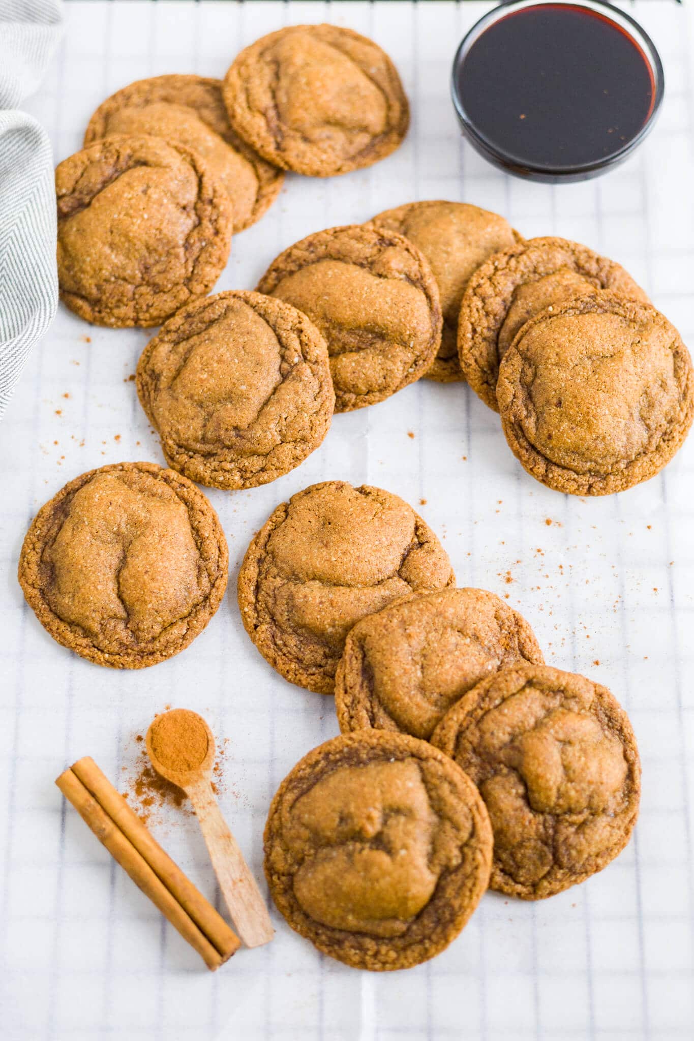 paleo molasses cookies spread out on parchment paper on a cooling rack