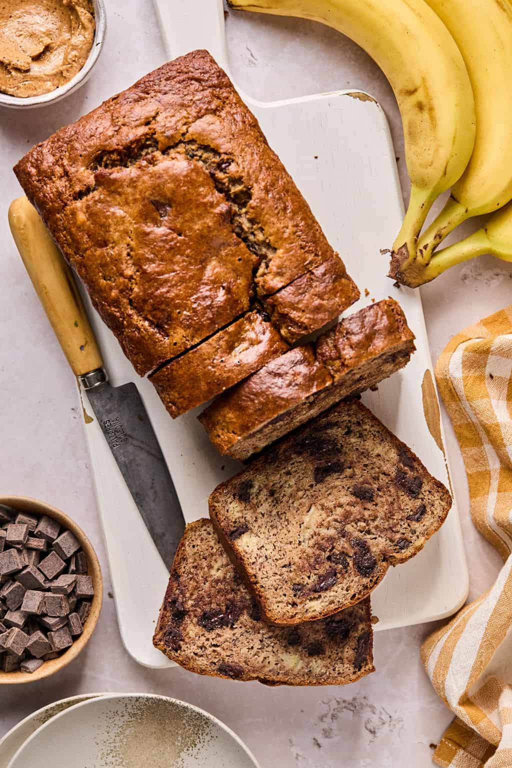 a loaf of paleo banana bread sliced on a cutting board.