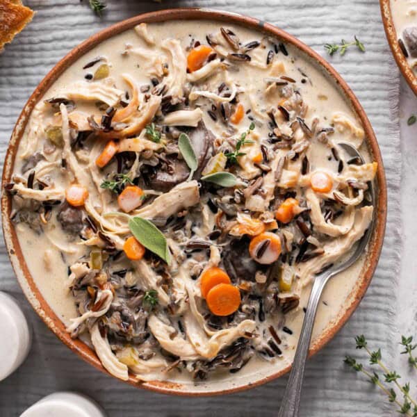 a bowl of creamy chicken and wild rice soup in a bowl with a spoon.