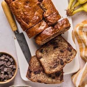 a loaf of paleo banana bread sliced into pieces on a cutting board.